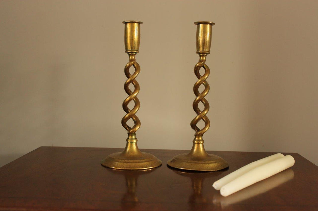 Sold at Auction: A pair of brass barley twist candlesticks.